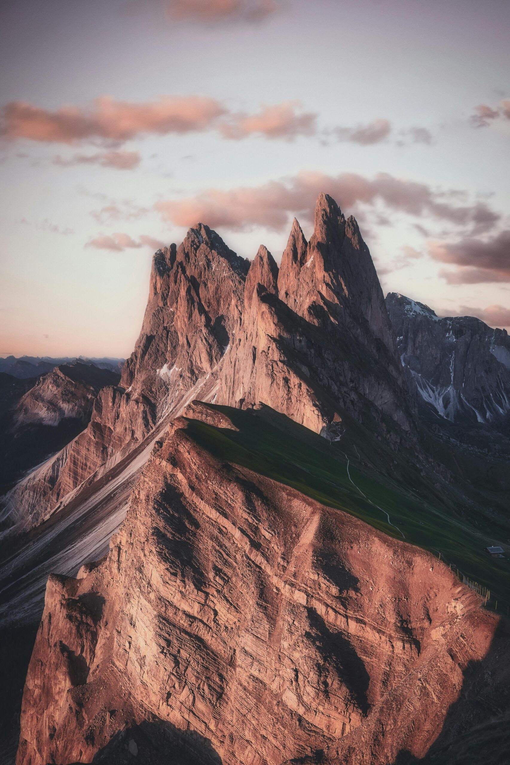 Home Breathtaking view of the sharp peaks of Seceda in the Dolomites during twilight, highlighting natural beauty.